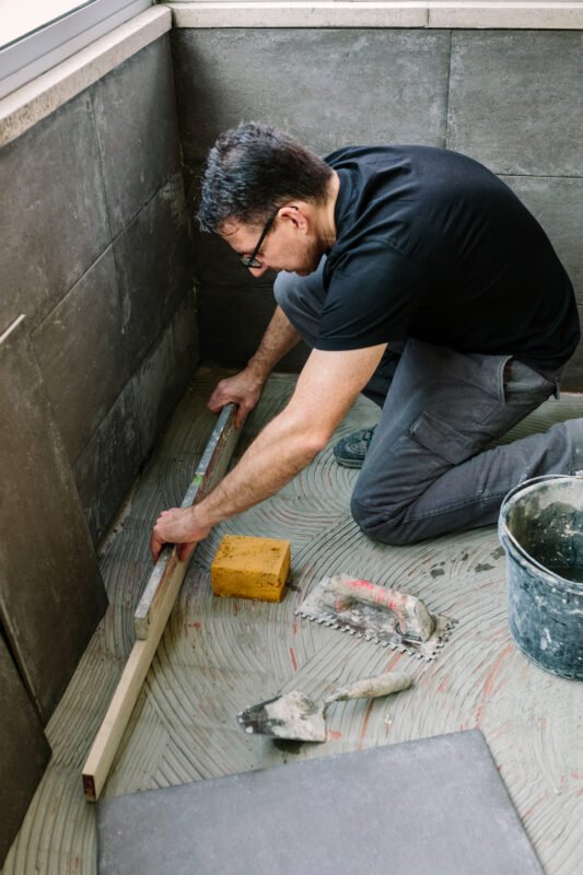Bricklayer checking floor with a level