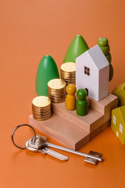 Conceptual composition of wooden steps with coins, model of a house as the growth of financial investments in real estate